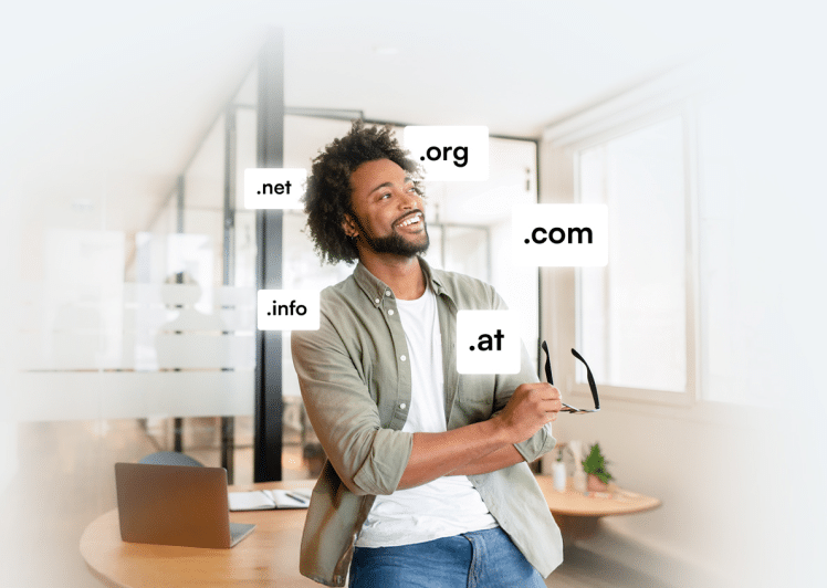 Mann mit Laptop und Domainendungen